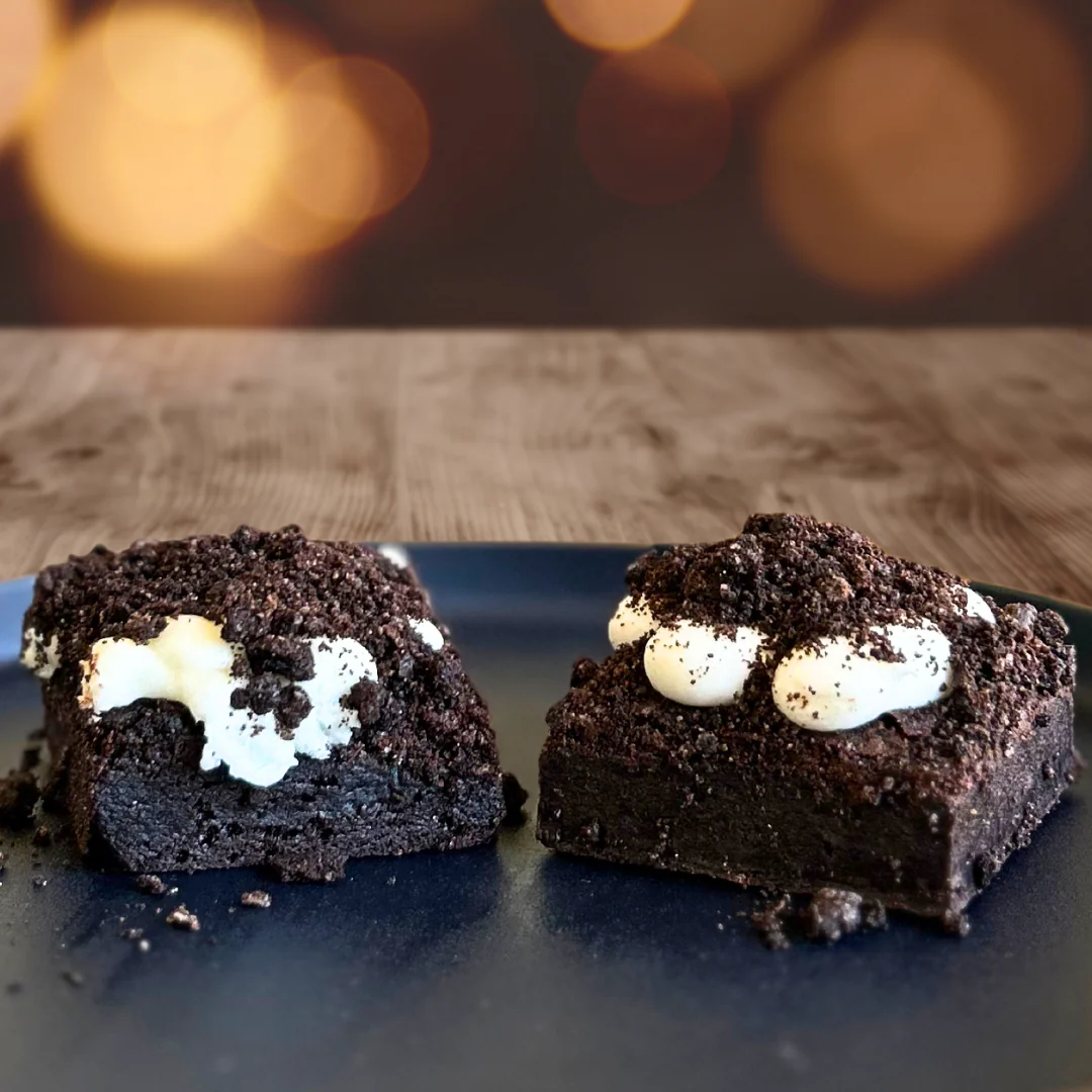 Cookies and cream brownies coated in dark cookie crumble with vanilla cream pockets